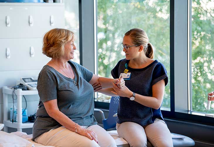 A provider examines a woman's arm.