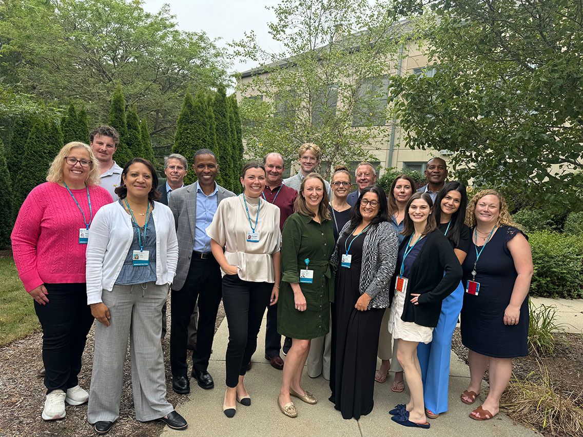 Team members pose in a garden.