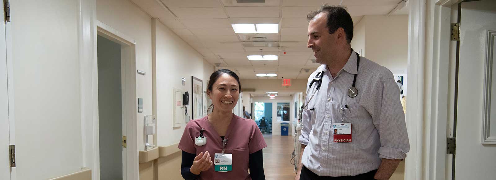 Physician walking with nurse at Spaulding Nursing and Therapy Center Brighton.