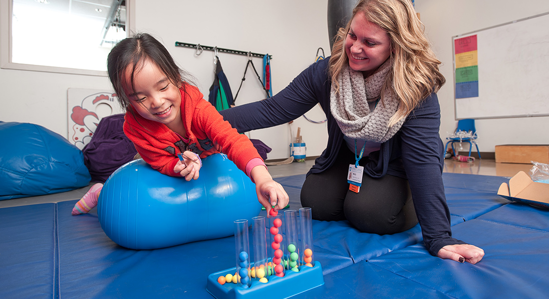 pediatric patient with physical therapist in gym