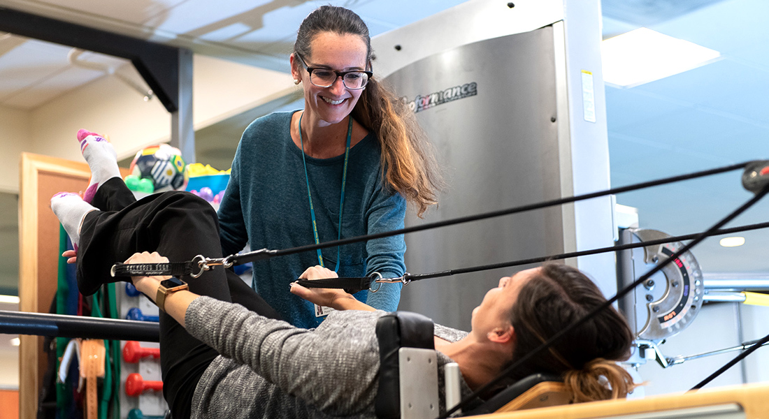 Patient using rehab equipment at Spaulding Outpatient Center Malden