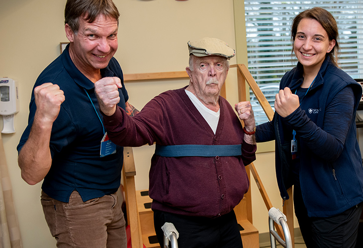 Orleans Outpatient team members flexing with elderly patient