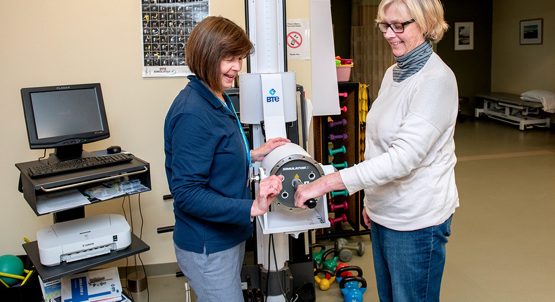 Patient and physical therapist using rehab machine at Spaulding Outpatient Center Orleans