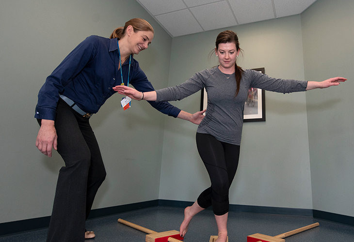 Quincy Outpatient team member assisting patient in rehab