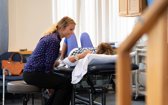 Wellesley Outpatient team member assisting patient with rehab
