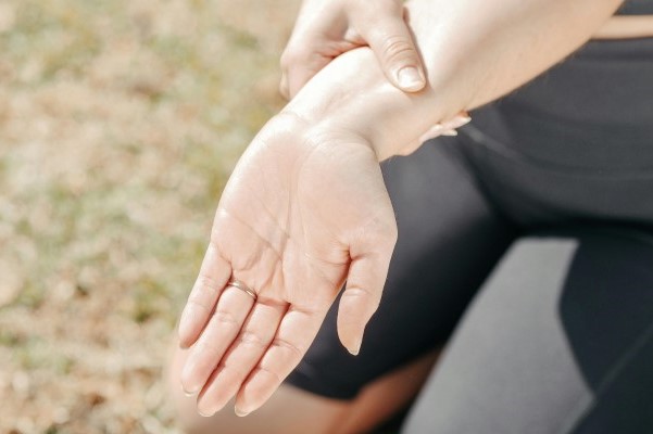 a person wearing workout clothes holding their wrist