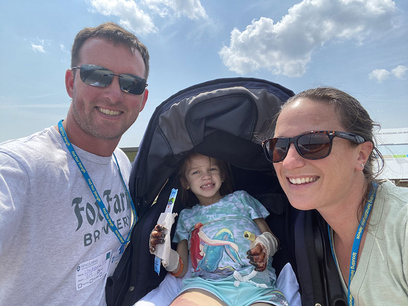 Addy outside with her parents.