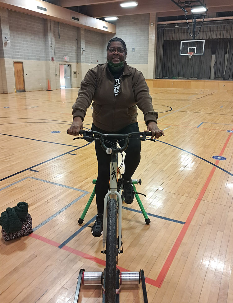 Lisa using a stationary bicycle at the gym.