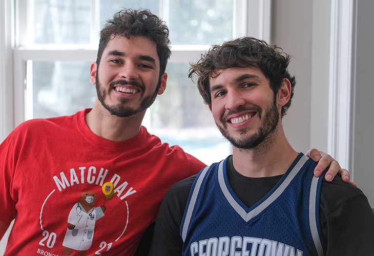 Nick and his twin brother Tim shoulder-hugging in team shirts.