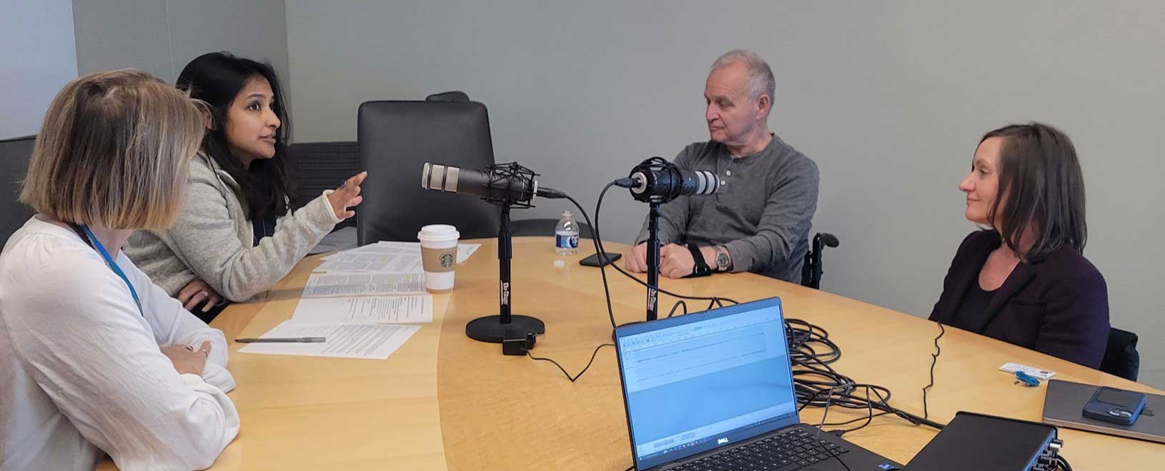 The panelists talking animatedly around a table during the podcast.