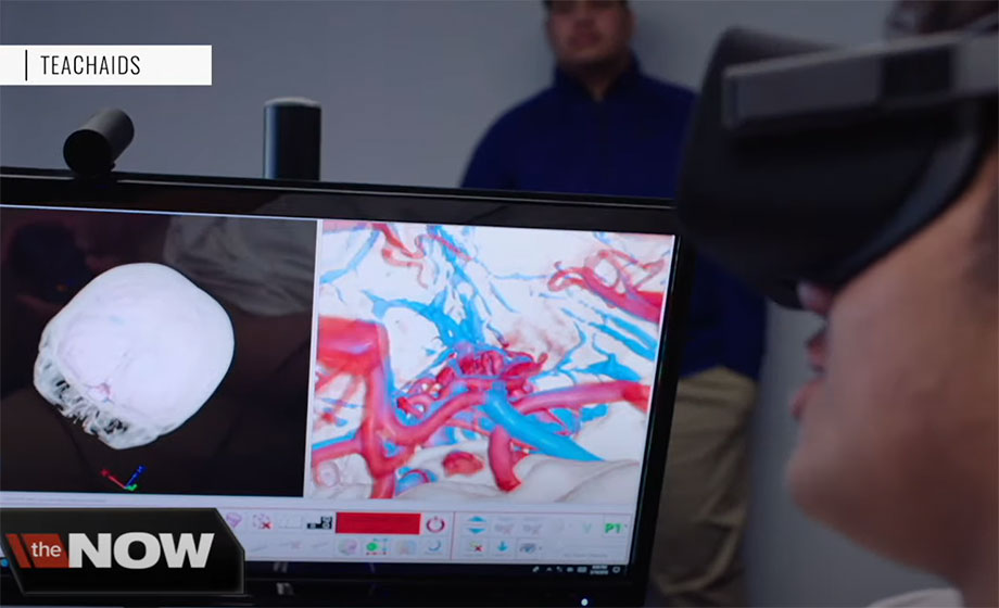 A young man uses a VR headset while a screen displays his medical scans.